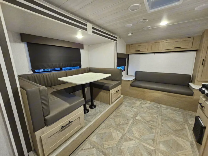 Compact RV rental interior with a u-shaped dinette, kitchen, and comfy seating, perfect for road trips.. Forest River Salem Cruise Lite 2024