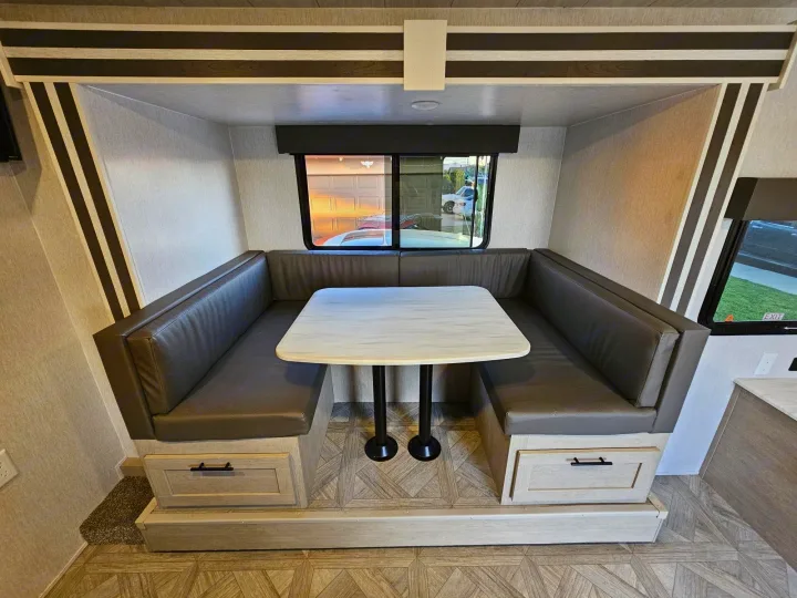 RV rental interior: cozy dinette booth with gray seating, removable table, and under-seat storage drawers.. Forest River Salem Cruise Lite 2024