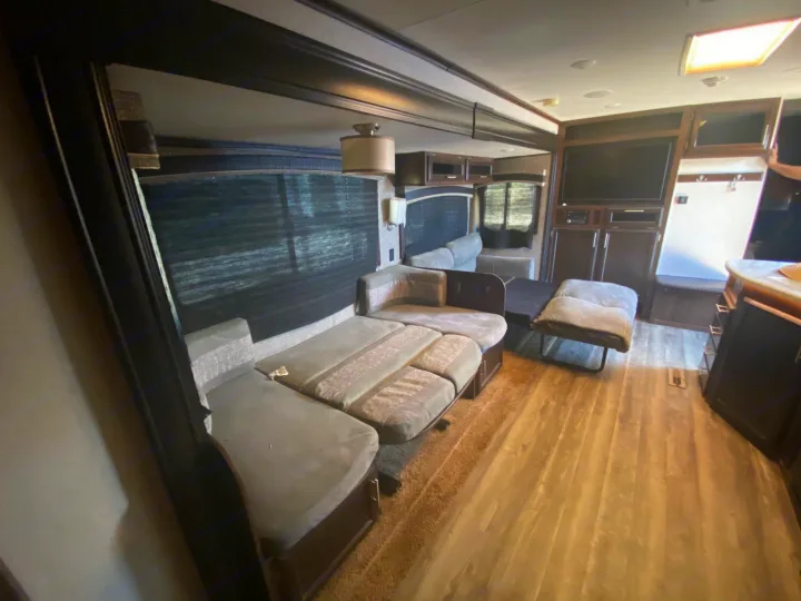 Spacious RV rental living area featuring a large sectional sofa, entertainment center with TV, and light wood flooring.. Jayco Jay Flight 2018