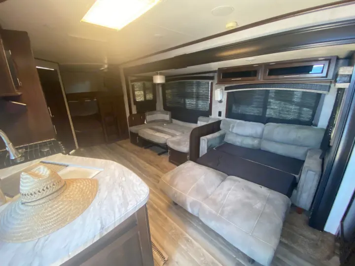 Inside this clean RV rental: living area with two sofas (one extended), kitchen, and wood flooring.. Jayco Jay Flight 2018