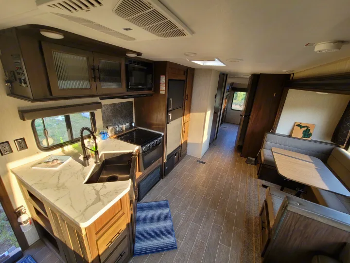 Bright RV rental interior showcasing a modern kitchen, dinette, and comfortable living space bathed in sunlight.. Forest River Cherokee 2020