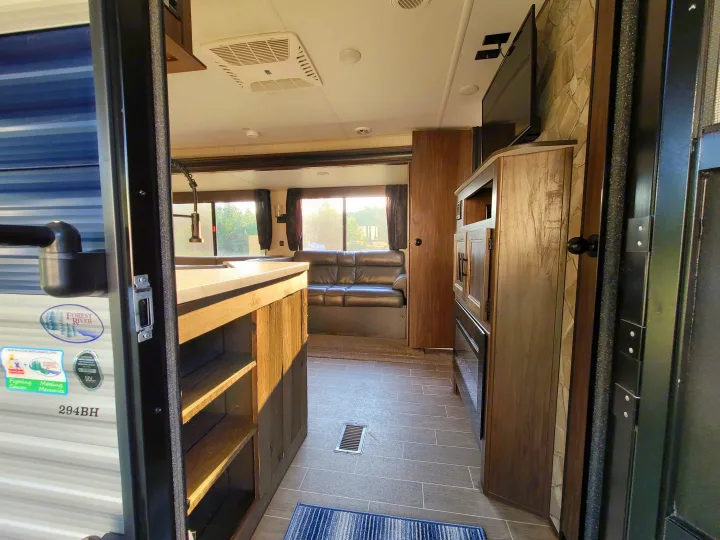 RV rental interior from entry: a spacious living area with kitchen, sofa, and entertainment setup.. Forest River Cherokee 2020