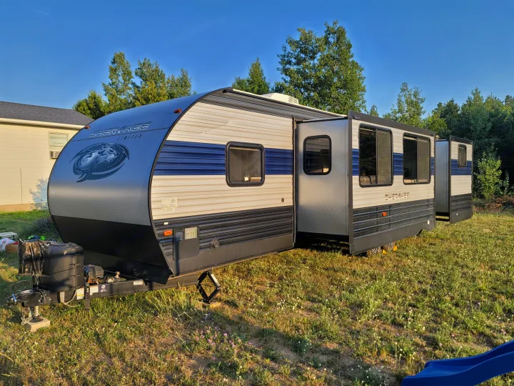A Cherokee Limited RV rental is parked with its slide-out extended on a grassy lot, ready for travel.. Forest River Cherokee 2020