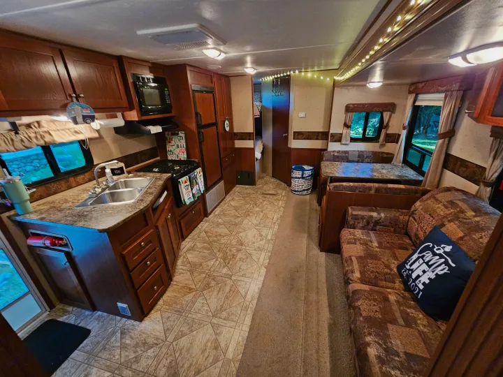 Spacious and cozy RV rental interior, featuring a full kitchen, dining area, and comfortable living space.. Crossroads RV Zinger 2010
