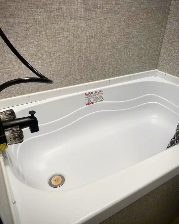 Clean white bathtub and shower in an RV rental, offering comfortable bathing during travel.. Jayco Jay Flight SLX 2022