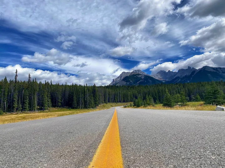 Embark on an RV rental journey! A long road extends through lush forests toward majestic mountains & a cloudy sky.. Jayco Jay Flight SLX 2022