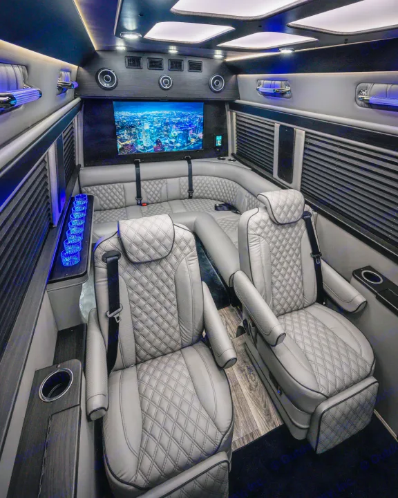 Rent a luxury RV: Custom van interior features plush grey seating, a large TV, and serene blue lighting.. Midwest Automotive Designs Ultimate Coach 2023