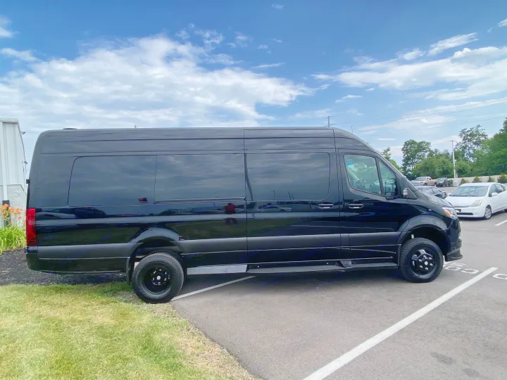 Sleek black Mercedes Sprinter van, ideal for an RV rental adventure under a blue sky.. Midwest Automotive Designs Ultimate Coach 2023