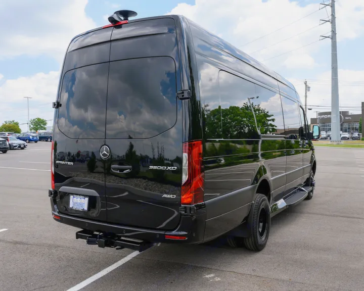 This black Mercedes-Benz Sprinter van, ideal for luxury rv rental, boasts tinted windows, a roof-mount, and tow hitch.. Midwest Automotive Designs Ultimate Coach 2023