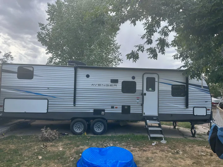 This Avenger RV rental, a spacious silver travel trailer, is parked outdoors. Ready for your adventure.. Avenger Avenger Trailer 2021