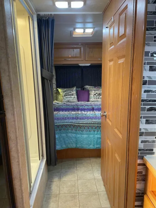 Step inside this cozy RV rental! Features a comfortable bedroom, shower, and living space with mosaic tiles. Ready for adventure.. Four Winds Majestic 2006