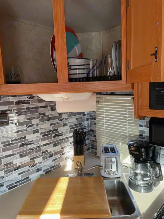 RV rental kitchen: counter, sink, toaster, coffee maker, dishes in cabinets, tiled backsplash. Bright and functional.. Four Winds Majestic 2006