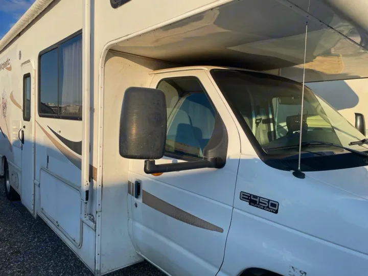 White Majestic Class C rv rental, a Ford E-450 motorhome. Shown from the front-side, with large mirrors and windows.. Four Winds Majestic 2006