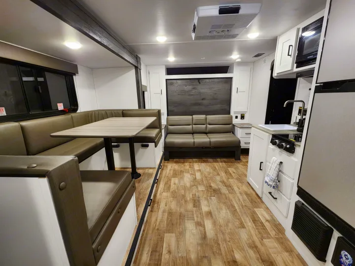 RV rental interior: a bright space with a dinette, a sofa area, and a functional kitchenette.. Keystone RV Hideout 2023