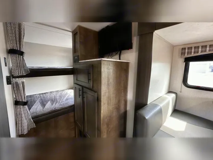 RV rental interior: comfy bunk beds, TV, and a dinette area for family meals and relaxation.. Venture Rv Sonic 2022