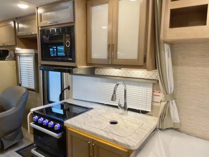 Spacious RV rental kitchen with microwave, stove, sink, and ample cabinets.. Thor Coleman 2022