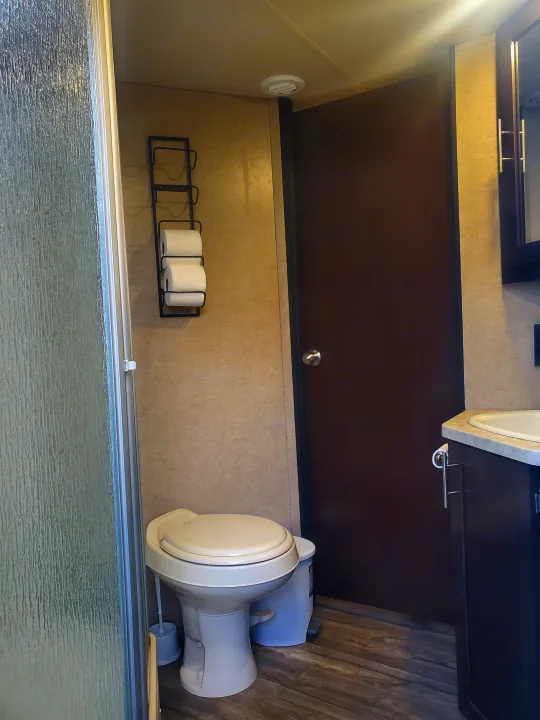 Compact RV rental bathroom features a toilet, shower, and vanity. Efficient layout for on-the-go living.. Forest River Cherokee Grey Wolf 2017
