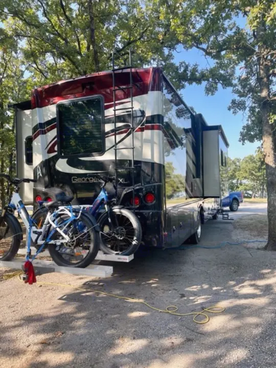 Spacious RV rental parked at a shady campsite with electric bikes on the rack, ready for adventure.. Georgetown XL 2013
