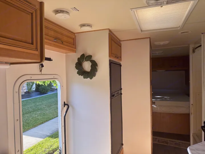 Interior of a clean RV rental, showing a bright kitchen, cozy bedroom, and compact bath. Ready for your travels.. Thor Majestic 2012