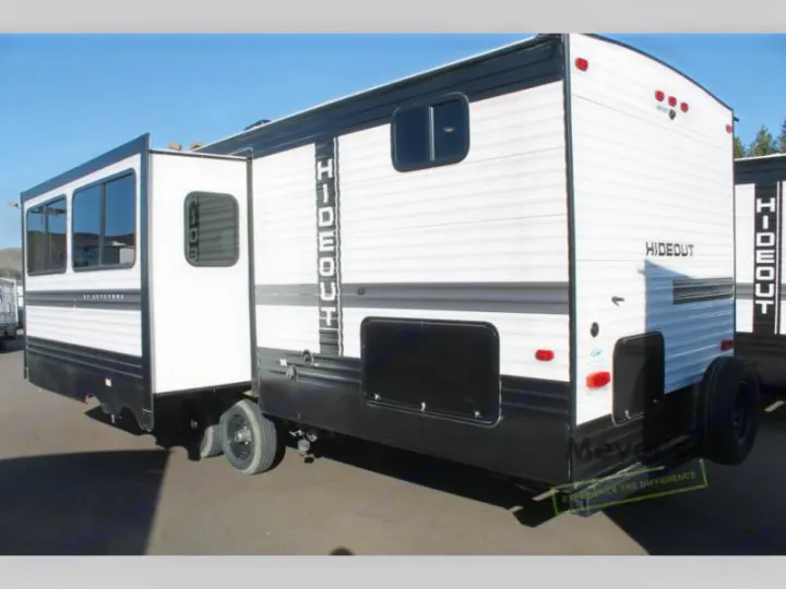 Exterior view of a white and black Hideout travel trailer with its slide-out extended, ready for rv rental.. Keystone Hideout 2022