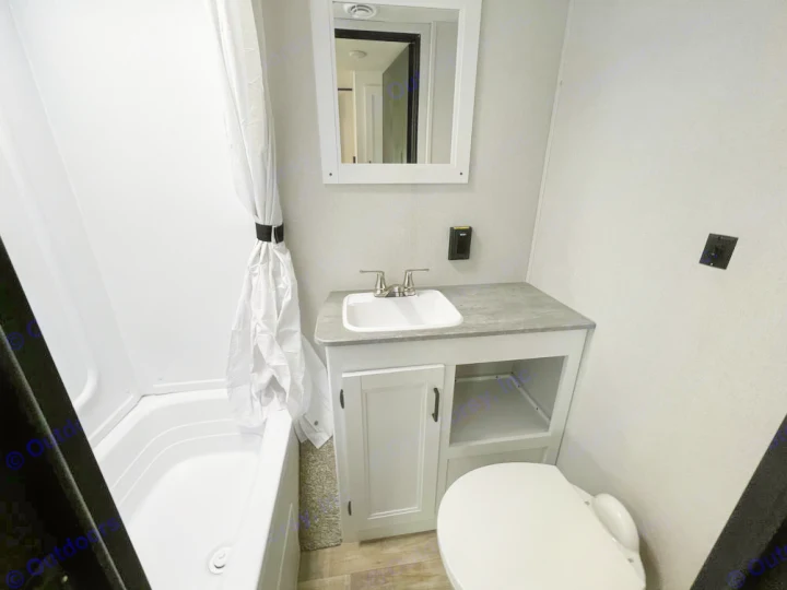 This RV rental bathroom features a compact shower, sink, toilet, and vanity, ensuring comfortable travels.. Keystone Hideout 2022