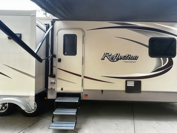 This Grand Design Reflection travel trailer, great for RV rental, features an extended slide-out, open door with steps, and an awning.. Grand Design Reflection 2015