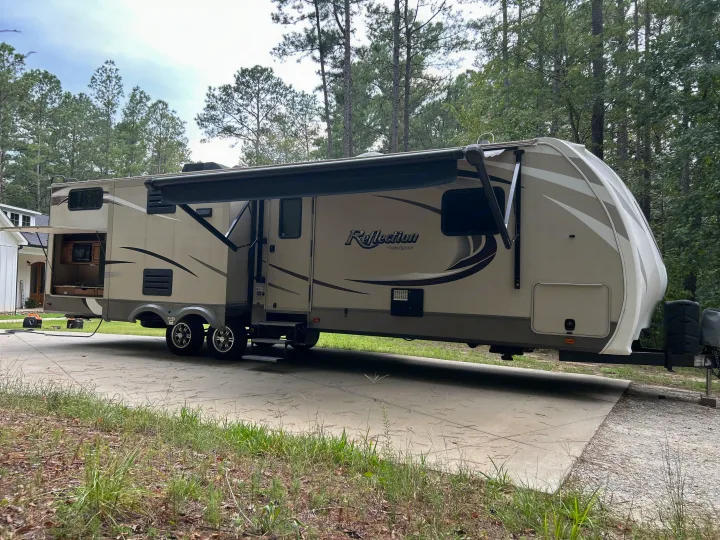Spacious Grand Design Reflection travel trailer RV rental with outdoor kitchen, slide-outs, parked on concrete.. Grand Design Reflection 2015