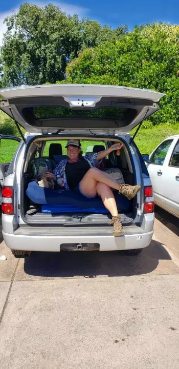 Happy woman enjoys her SUV converted for car camping. A comfy, flexible alternative to an RV rental.. Xplorer Explorer 2007
