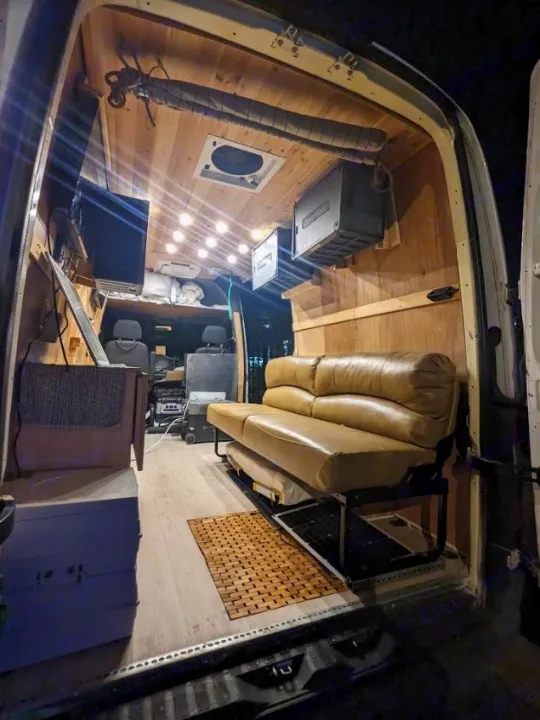 Experience van life! This RV rental boasts a comfortable, wood-paneled camper interior with a cozy couch.. Mercedes Benz Sprinter 2500 2014
