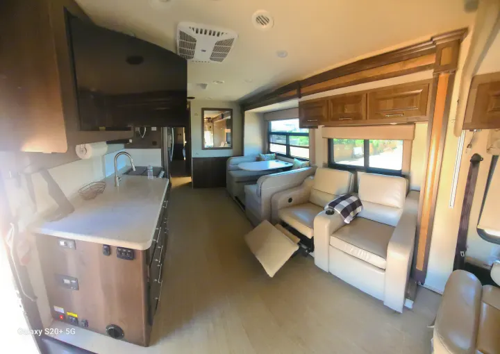 Spacious RV rental interior featuring a kitchen, comfortable recliners, and dinette, ideal for travel.. Entegra Coach Vision XL 2020