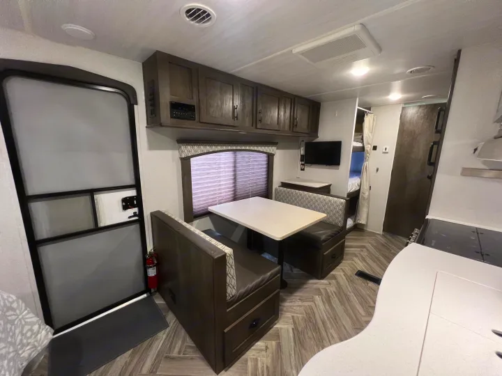 Spacious RV rental interior featuring a dinette, kitchen, and bunk beds, perfect for family adventures on the road.. Forest River Evo 2020