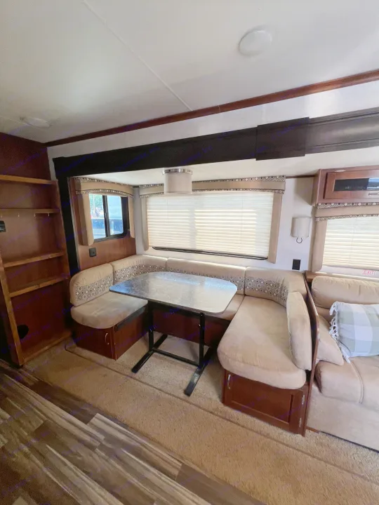 RV rental living area: U-shaped dining booth, comfy couch, and shelving, with mixed flooring for cozy travels.. Jayco Jay Flight 2017