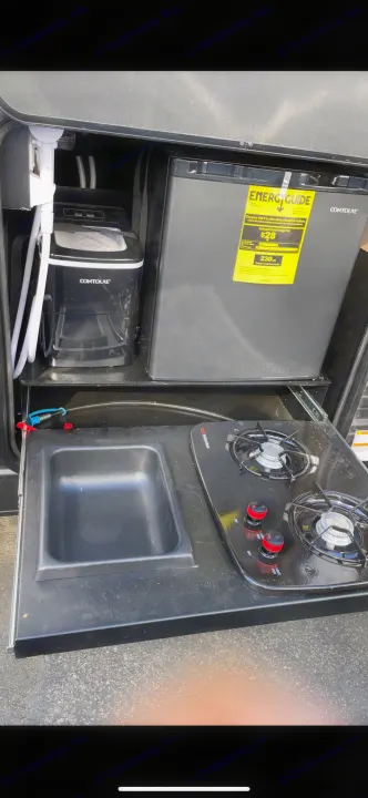 RV rental's convenient outdoor kitchen featuring a fridge, ice maker, sink, & 2-burner cooktop for easy camping.. Forest River Cherokee Grey Wolf 2021
