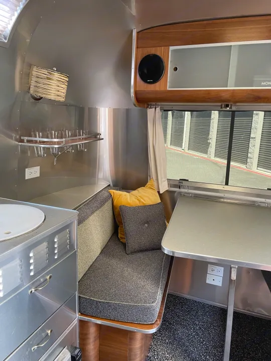 This Airstream rv rental offers a sleek interior with polished aluminum walls, wood trim, comfy dinette, and a compact kitchen.. Airstream International 2007