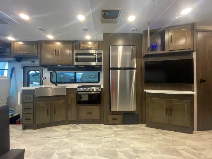 Spacious and modern RV rental interior featuring a full kitchen with stainless steel appliances, cabinetry, and living area.. Coachmen MIRADA 35ESF 2026