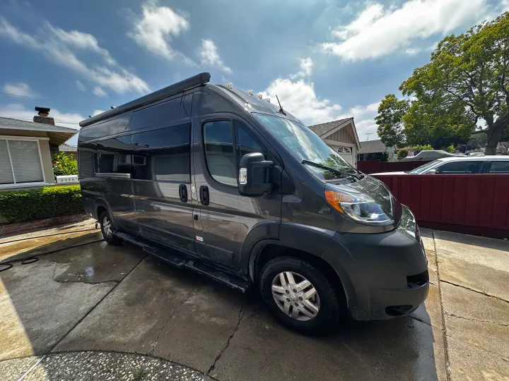 Explore in style! This sleek dark grey camper van, perfect for RV rental, awaits its next journey on a sunny day.. Thor Sequnce 2023