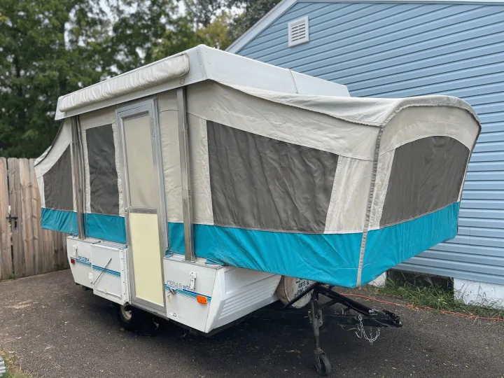 White & grey pop-up camper with teal accents, fully set up & ready to be your next rv rental for camping adventures!. Coleman Destiny Cedar 1992