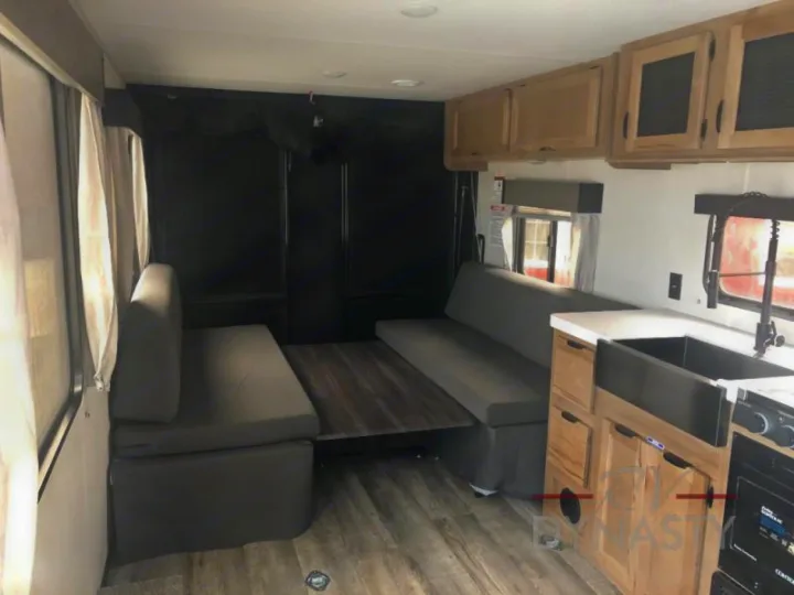Check out this RV rental's versatile interior with a modern kitchen, convertible bench seating, and dining table.. Forest River Cherokee Grey Wolf 2024