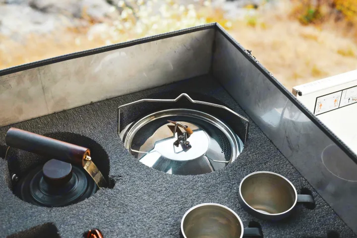 Organized rv rental camping kitchen with kettle, mugs, and coffee grinder in custom foam storage for easy outdoor cooking.. Mitsubishi Delica 2005