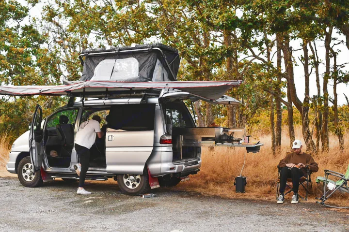 Explore the outdoors with this RV rental van, featuring a rooftop tent and a fully equipped pull-out kitchen setup.. Mitsubishi Delica 2005