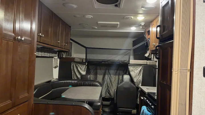 Spacious rv rental interior: A comfortable camper living space with dinette, kitchen, and bunk area with safety net.. Forest River Sunseeker 2017