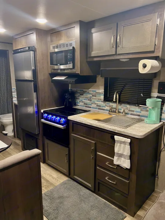 Spacious RV rental kitchen with modern appliances, sink, and stylish tile backsplash, ready for your trip.. Jayco Jay Flight SLX 2021