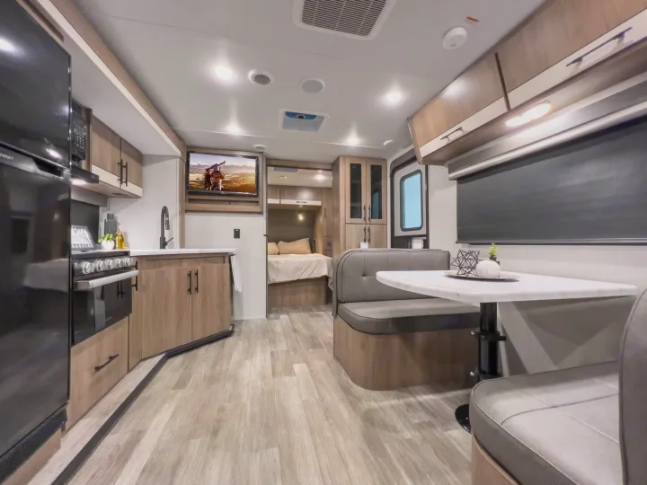 Spacious RV rental interior featuring a full kitchen, dining area, and comfortable bed nook.. Grand Design Imagine XLS 2023