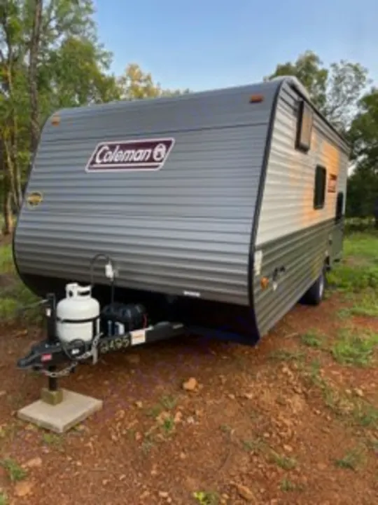 This gray Coleman travel trailer RV rental is parked outdoors, ready for your next camping adventure.. Dutchmen Coleman Lantern LT 2023