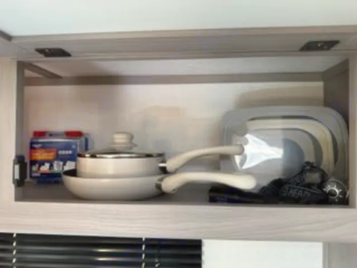 RV rental kitchen storage: compact, nesting pots and pans alongside collapsible containers, ready for your camping trip.. Dutchmen Coleman Lantern LT 2023