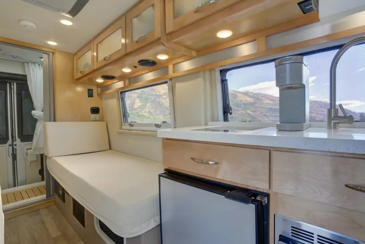 Spacious RV rental interior featuring a modern kitchen with sink and coffee maker, a convertible living space, and shower.. Coachman Nova 20RB 2023