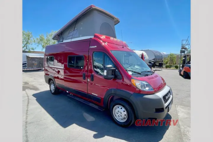 This vibrant red pop-top camper van, perfect for an rv rental adventure, is parked outdoors on a sunny day.. Winnebago Solis 2022