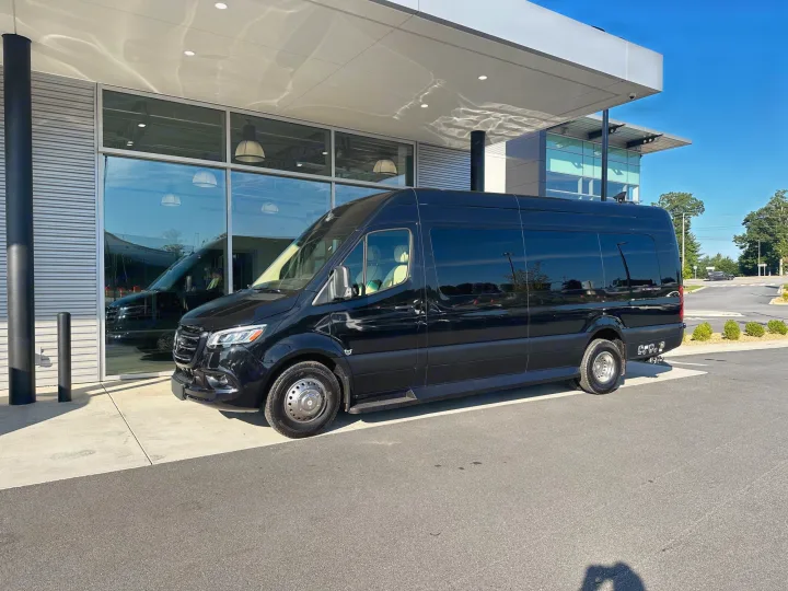 A black Mercedes-Benz Sprinter luxury van, an 'Ultimate Coach' ideal for RV rental, parked by a modern building.. Ultimate Toys Ultimate Coach 2024