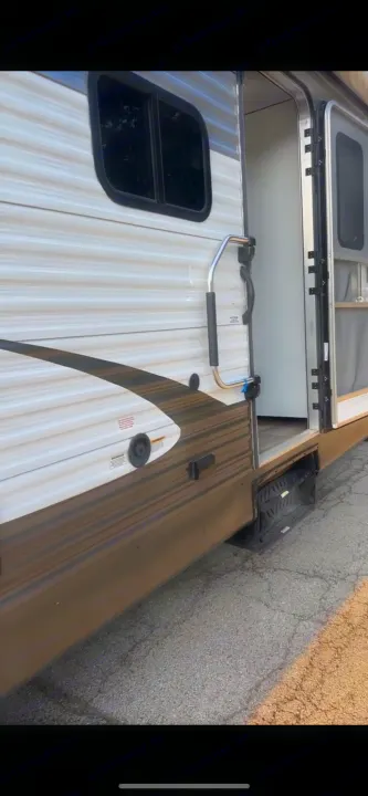 This RV rental features a convenient side door with steps and a grab bar, perfect for outdoor adventures.. Gulf Stream Conquest 2016