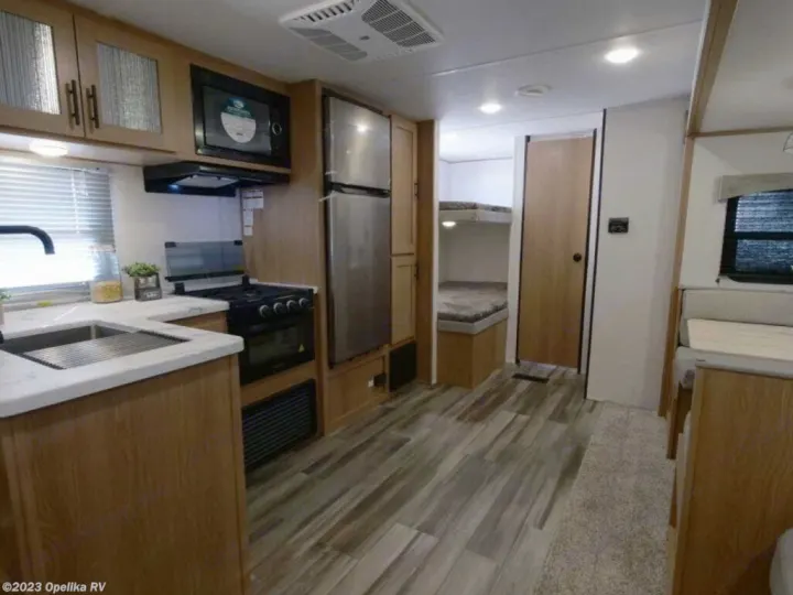 Step inside this RV rental showcasing a full kitchen, comfortable bunk beds, and a dinette for family trips.. Forest River Avenger LE 2022